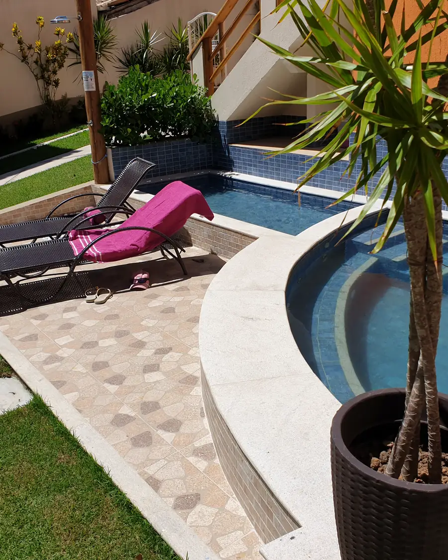 Piscina com hidromassagem e espreguiçadeiras na área comum