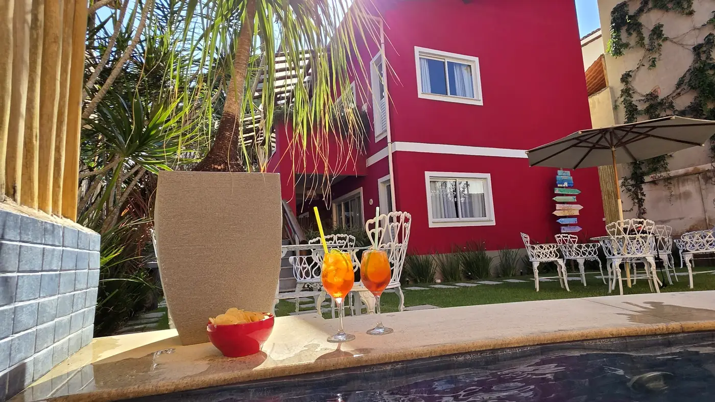 Área da piscina voltada para o jardim e a fachada vermelha
