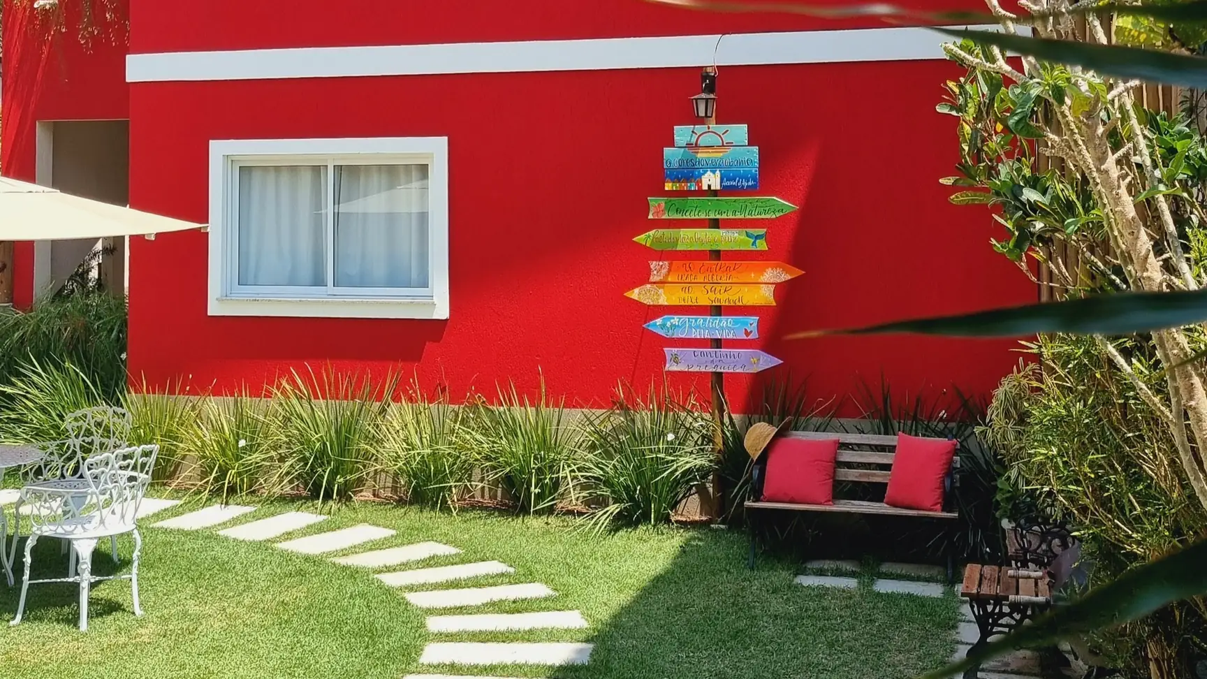 Fachada vermelha e jardim do Cores do Verão